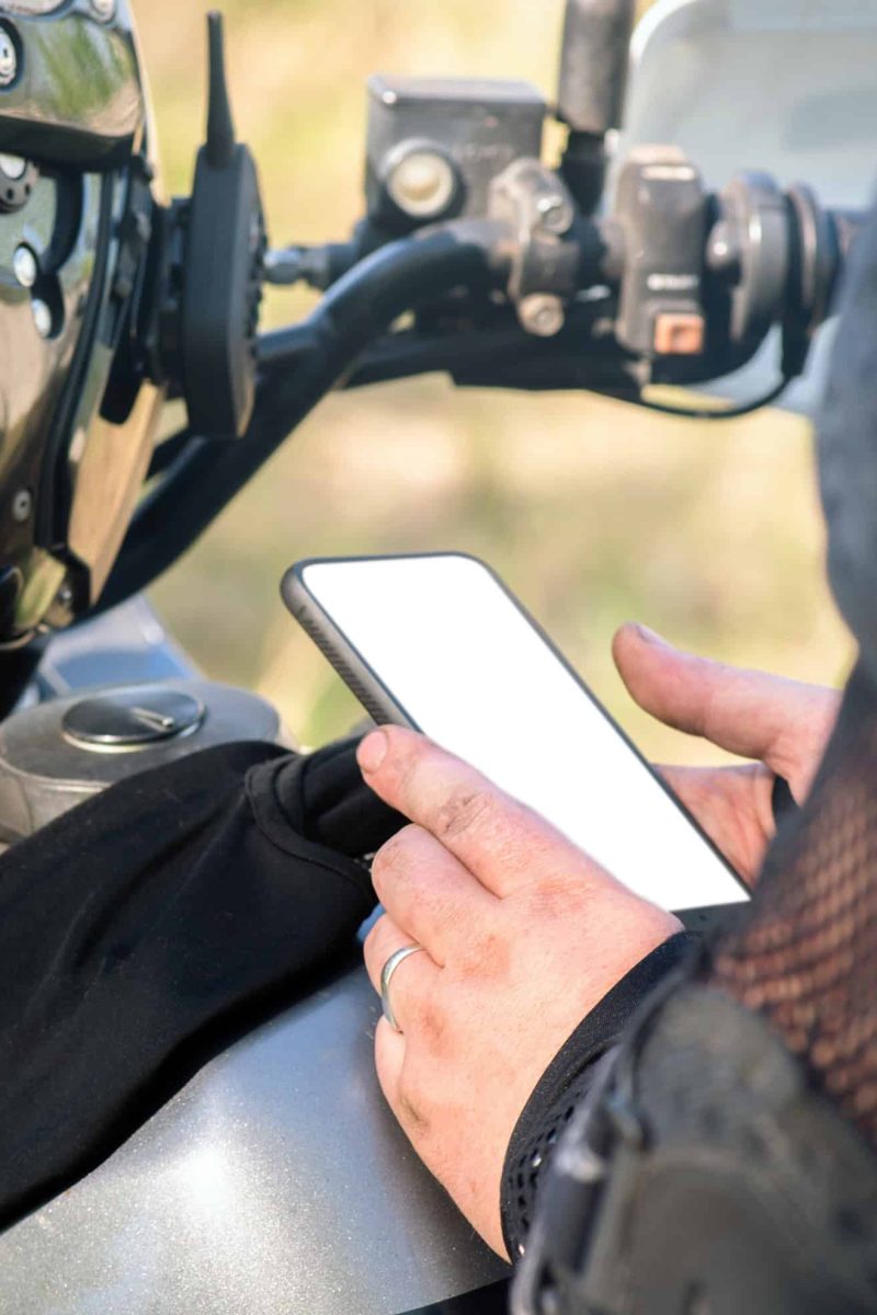 Motor,Biker,Is,Showing,In,Hands,A,Blank,Screen,Mobile Motor biker is showing in hands a blank screen mobile phone. Online navigator.